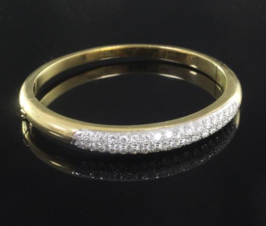 An 18ct gold and diamond hinged bangle, gross weight 28.8 grams.